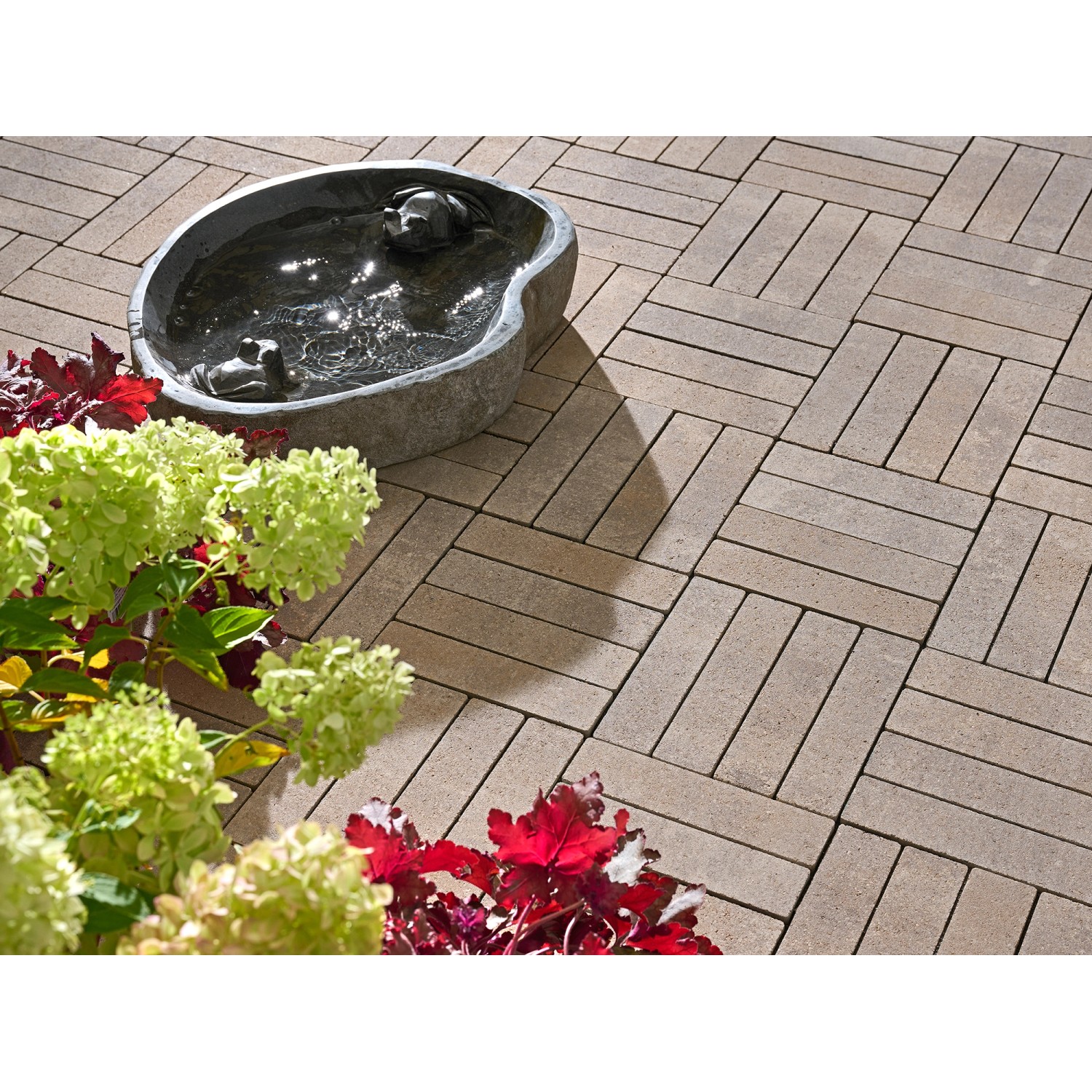 Verlegte, siennafarbene Kann Pflastersteine Rimero im Fischgrätenmuster mit Dekoration.