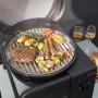 Schwarzer Char-Broil Elektrogrill Patio Bistro Cube E mit Grillgut und zwei Gläsern Wein.