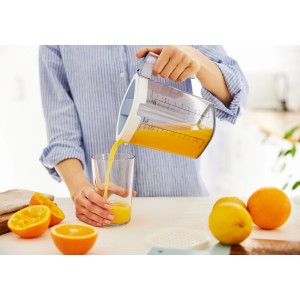 Rotho Messbecher Loft: Frau gießt Orangensaft ein. Küchenhelfer mit Skala, transparent/blau.