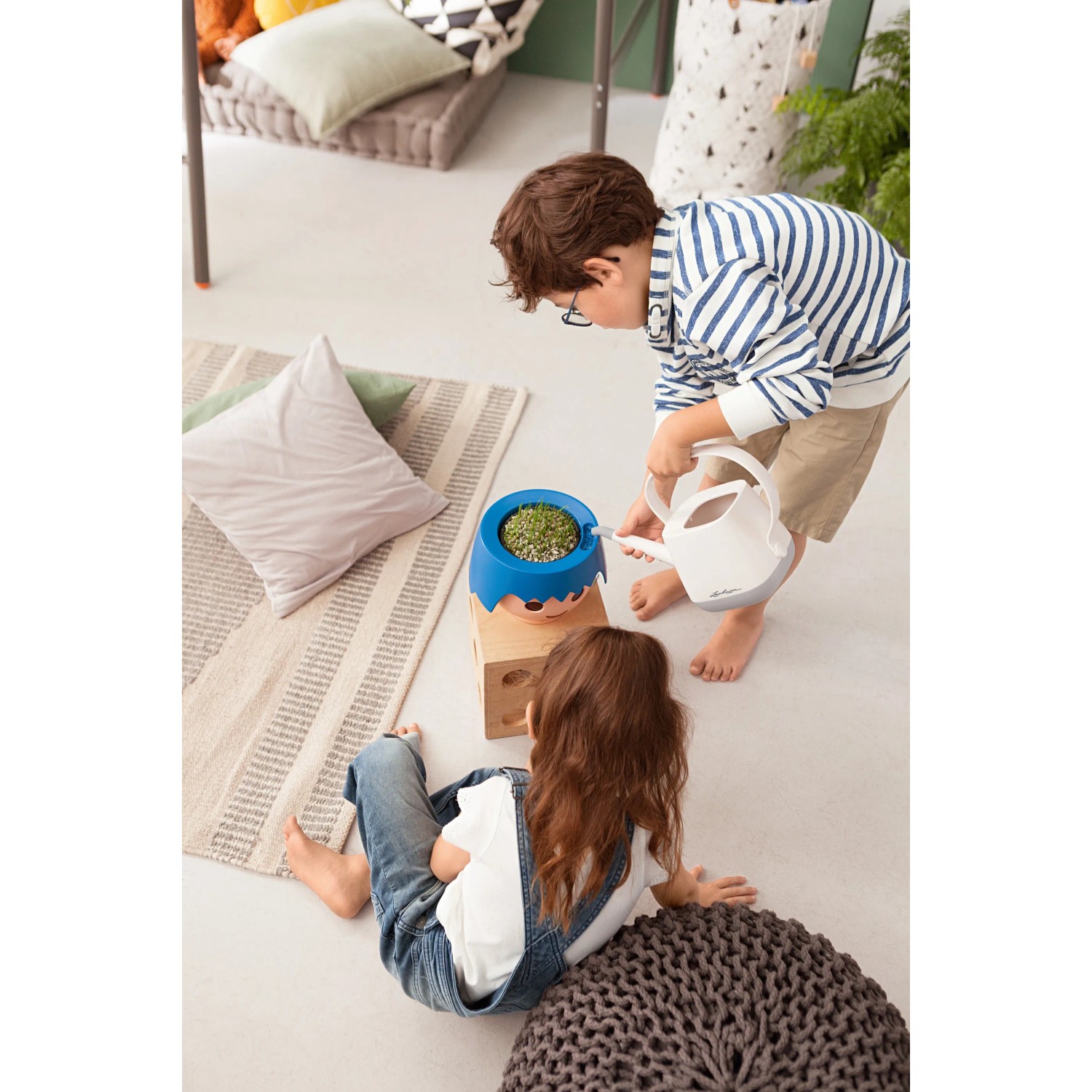 Kinder gießen Lechuza Ojo Pflanzgefäß (Ocean Blue) mit Gießkanne. Übertöpfe für Kinder.