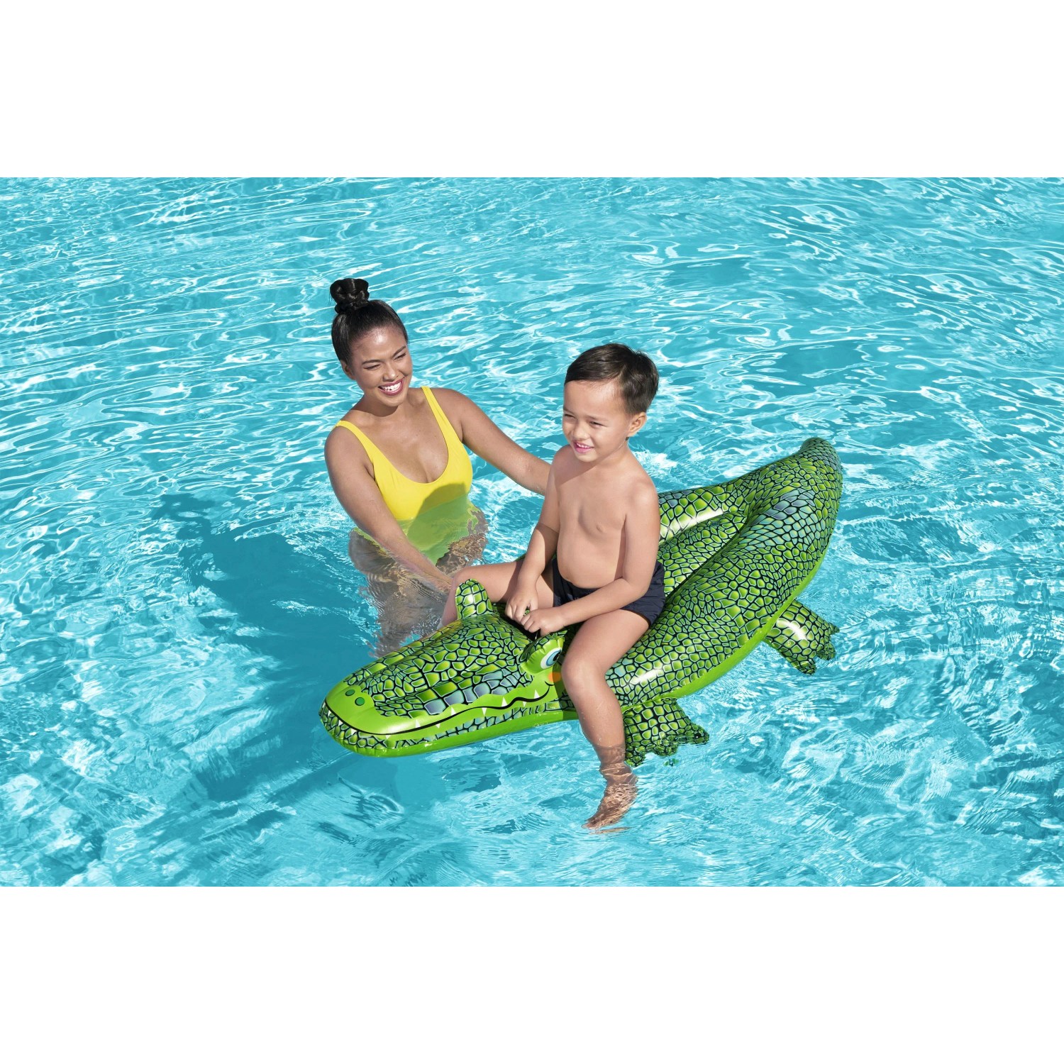 Kind auf Bestway Schwimmtier Krokodil im Pool, grüne aufblasbare Krokodil-Badeinsel.