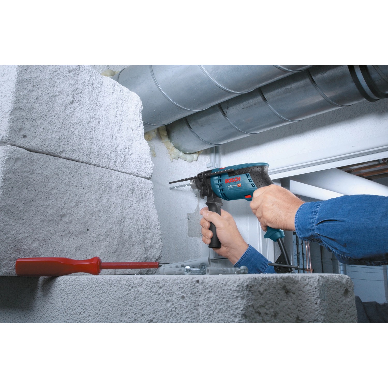 Bosch Professional GSB 13 RE Schlagbohrmaschine beim Bohren in Mauerwerk.