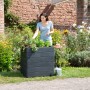 Garantia Hochbeet Ergo Quadro M 75 Stone im Garten mit Frau. Kunststoff-Hochbeet in Steinoptik.