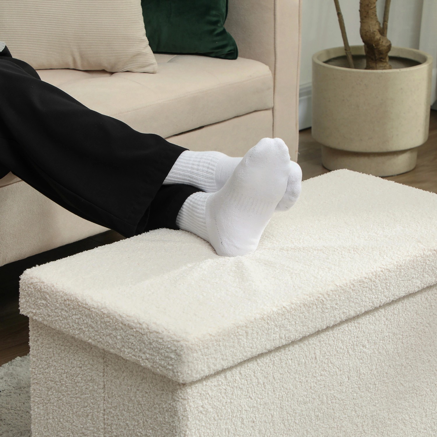 Cremeweiße HOMCOM Sitzbank mit Stauraum und Samtoptik als Fußablage genutzt.