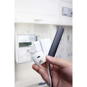 Stromzählerauslesegerät poweropti in Hand vor Stromzähler. Smart Home Set zur Verbrauchsmessung.