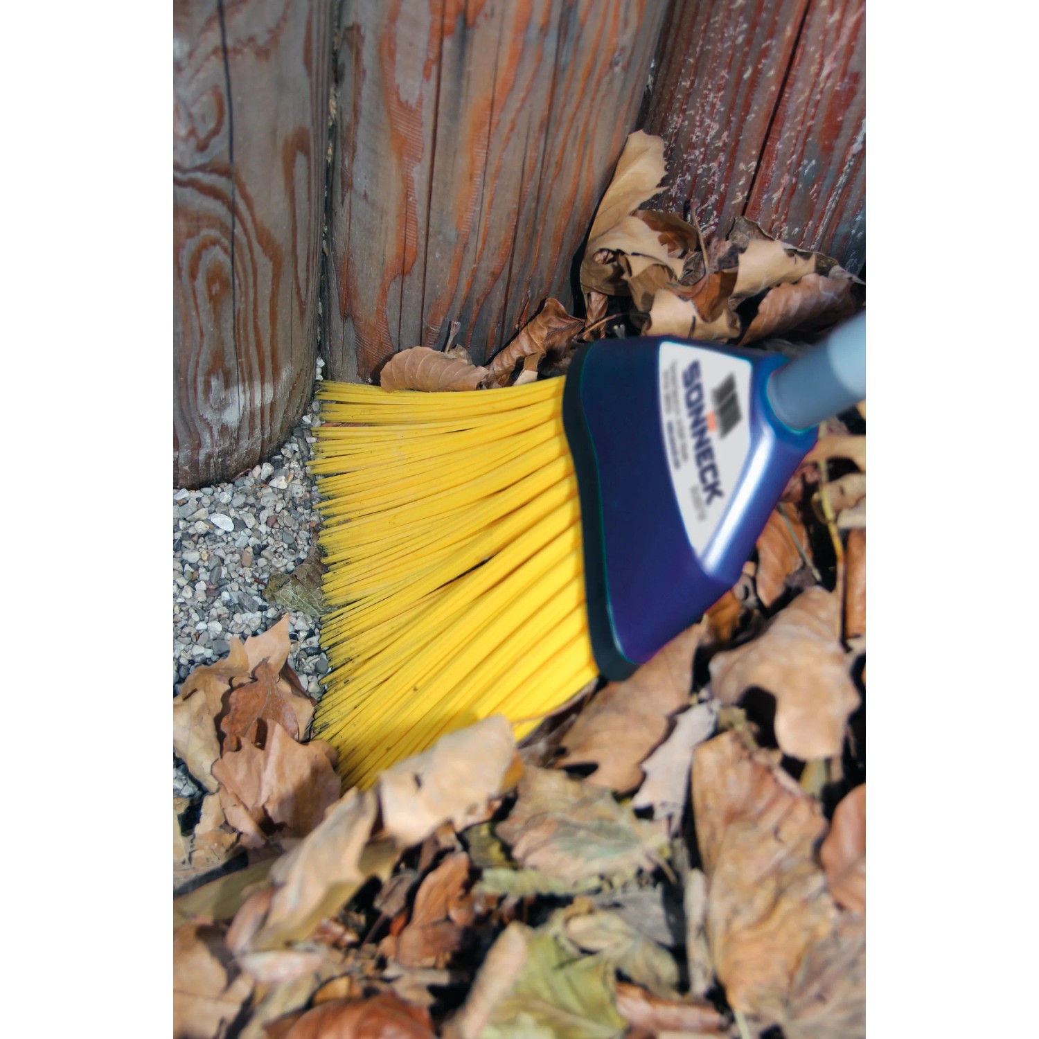 Sonneck Universalbesen mit gelben Borsten und blauem Kopf im Außeneinsatz.