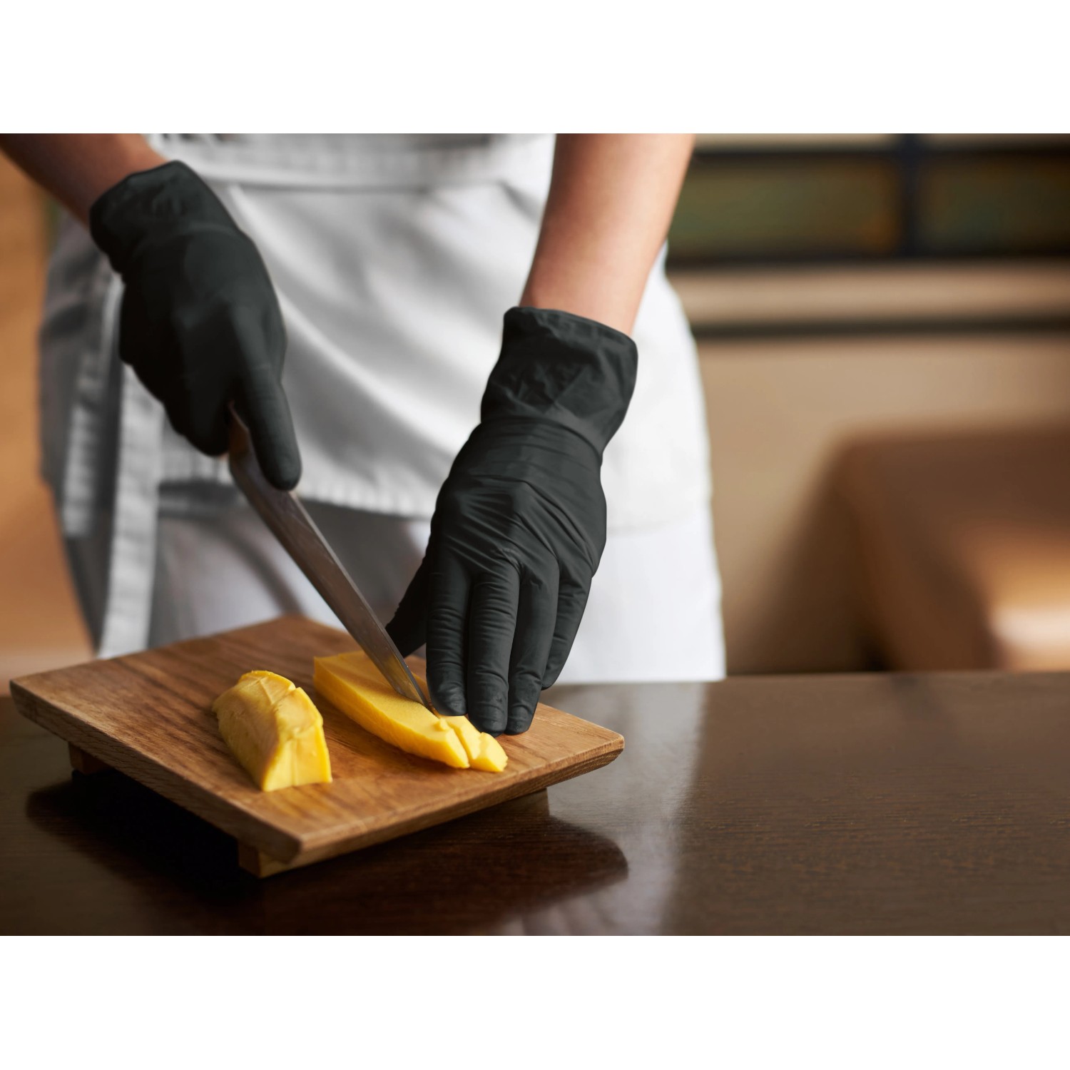Schwarze Einmalhandschuhe (50 Stk., Gr. L) beim Schneiden von Käse. Latexfrei, ideal für Allergiker.