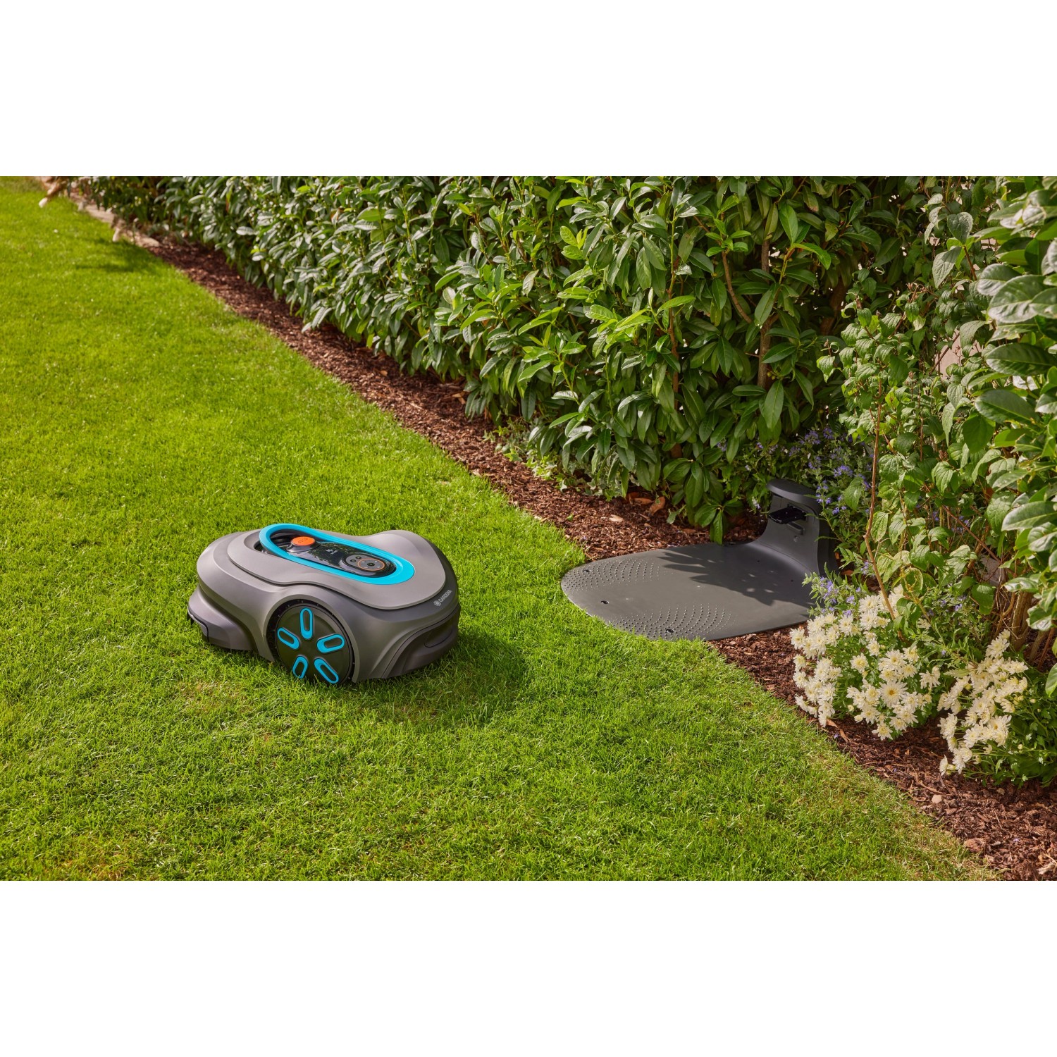 Gardena Smart Sileno Max Mähroboter 1.500 m² mit Ladestation auf Rasenfläche.