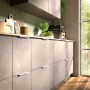 Moderne SOTECH Griffleiste BLANKETT Jane aus weißem Aluminium an grauen Küchenschränken, horizontal montiert.