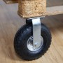Schwarze luftbereifte Bockrolle aus Gummi und silbernem Stahl, an Holzpalette montiert. Für schwere Lasten.