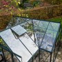 Halls Gewächshaus GardenRoom Set, grüne Rahmen, Glasdach mit geöffnetem Fenster, eingebettet in Garten.