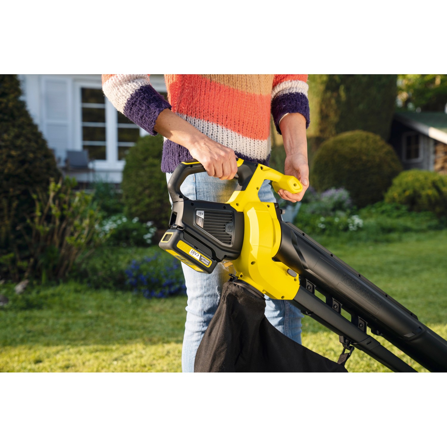 Kärcher Akku-Laubsauger BLV 18-200 mit Fangsack im Einsatz im Garten.