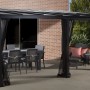 Sojag Terrassenüberdachung St. Barth, anthrazit, mit Tisch, Stühlen und Moskitonetzen.