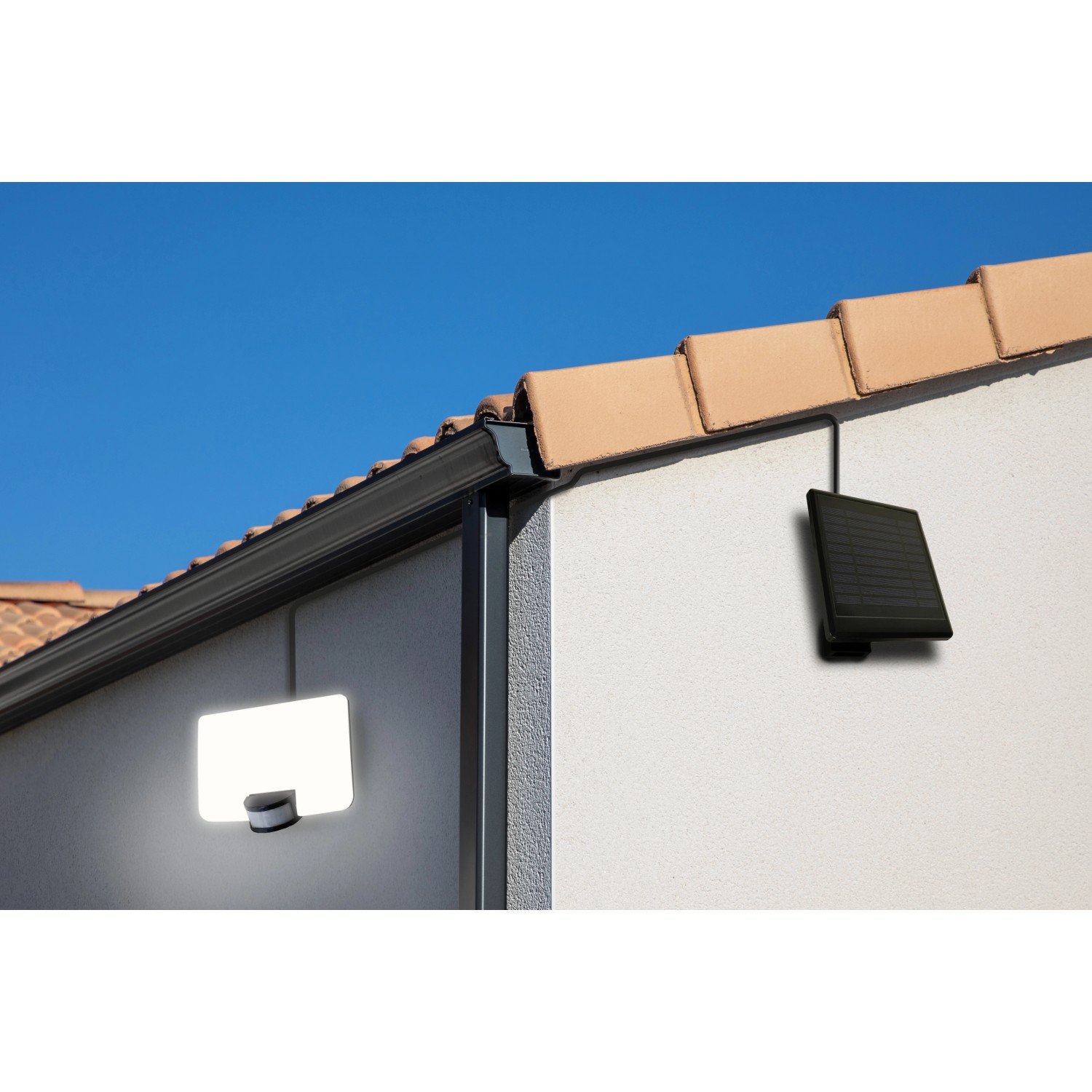 Schwarzer MegaLight Solar-LED-Strahler Sunflood mit Solarpanel an Hauswand.