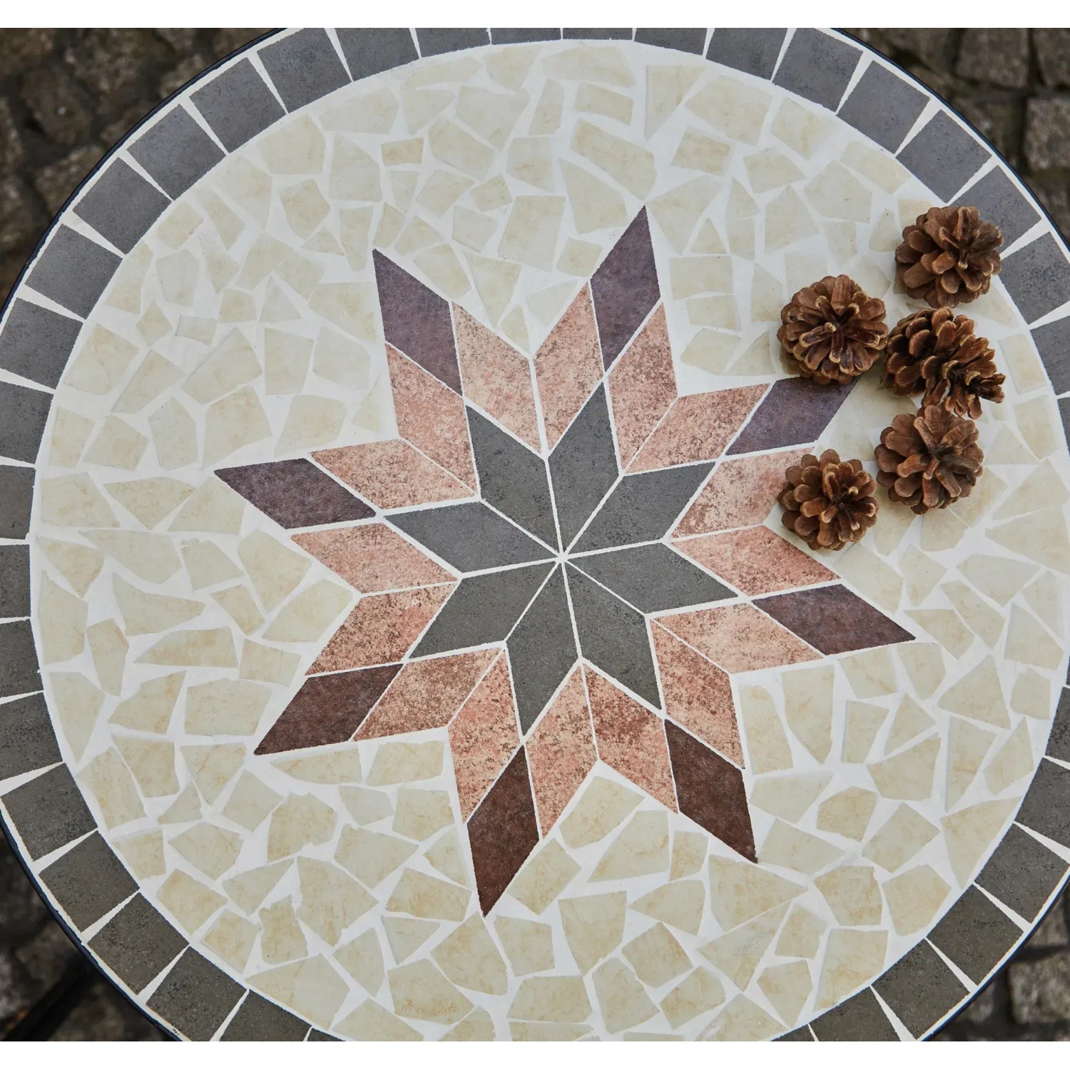 Runder, grauer Siena Garden Gartentisch Stella Ø 70 cm mit Sternmuster und Deko-Zapfen.