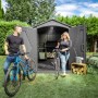Lifetime Kunststoff-Gartenhaus Stella 4,55 m² mit Fahrrädern und zwei Personen im Garten.