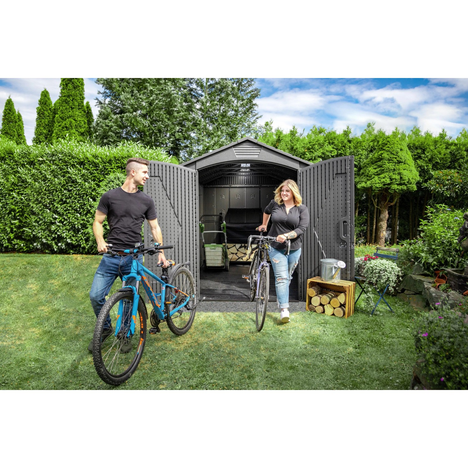 Lifetime Kunststoff-Gartenhaus Stella 4,55 m² mit Fahrrädern und zwei Personen im Garten.