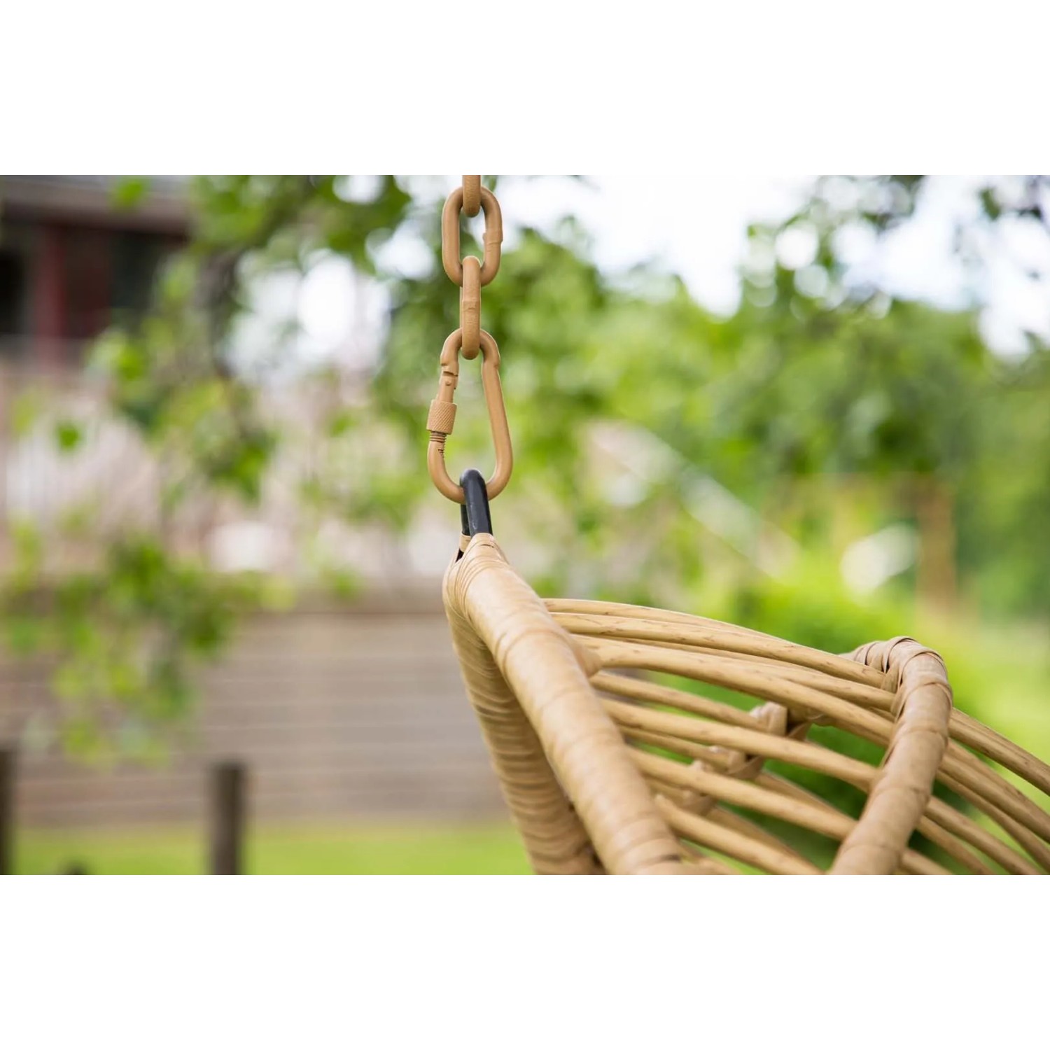 Detailaufnahme: Hängender Pulau Gartenstuhl in Natur mit Kissen. Gartenmöbel für entspannte Stunden.