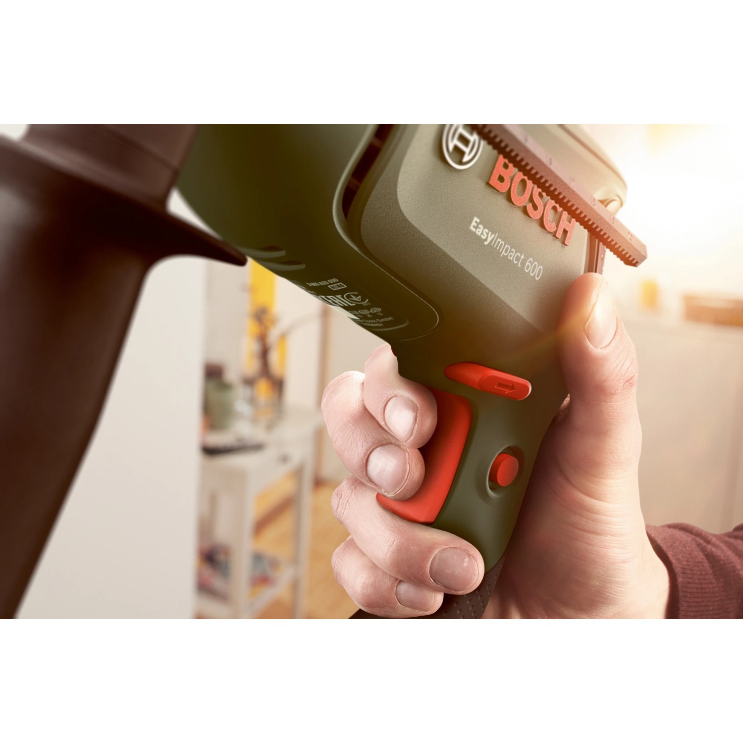 Bosch EasyImpact 600 Schlagbohrmaschine mit Tiefenanschlag in Hand gehalten.
