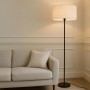 Schwarze QAZQA Stehlampe mit hellgrauem Schirm (50 cm) neben einem Sofa.