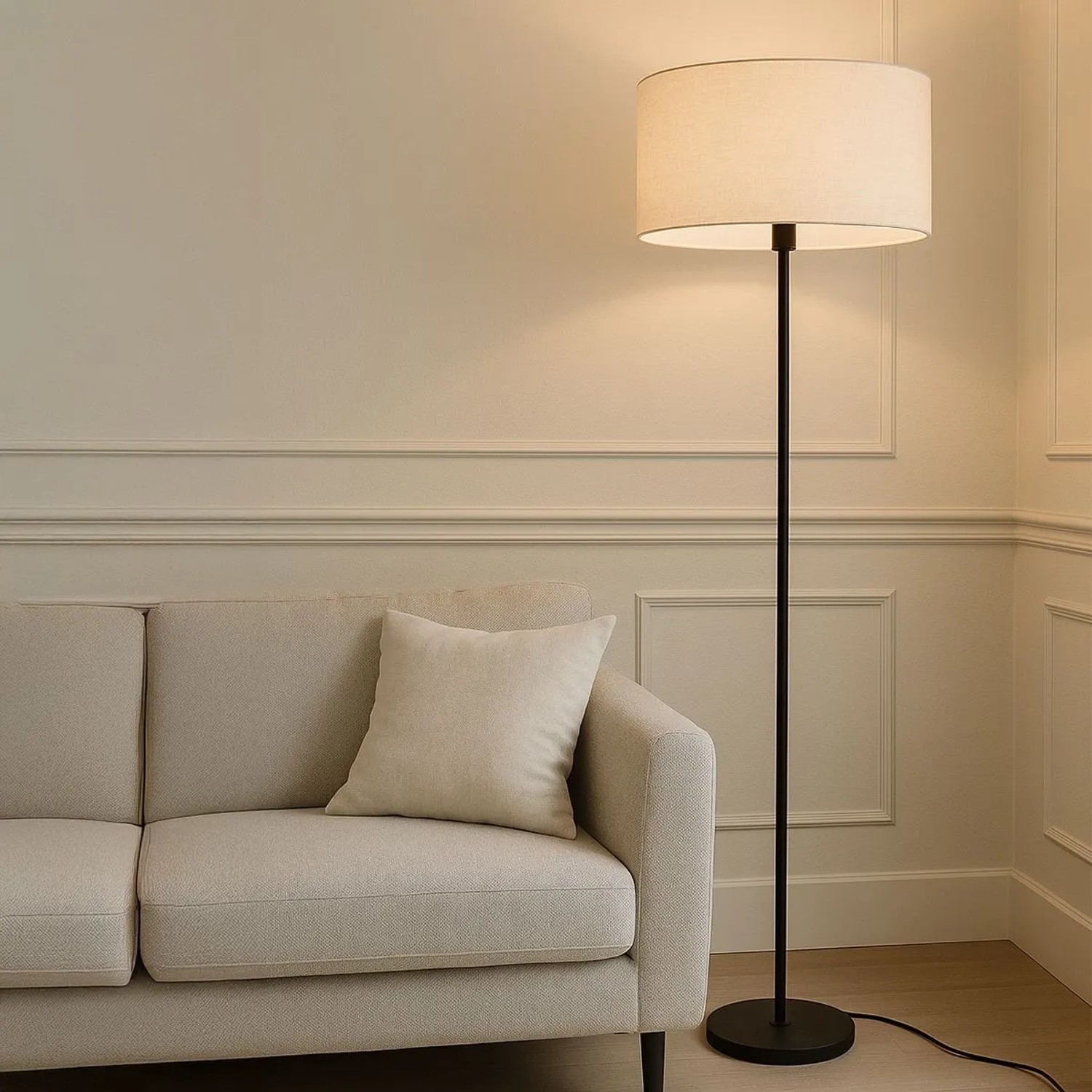 Schwarze QAZQA Stehlampe mit hellgrauem Schirm (50 cm) neben einem Sofa.