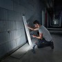 Mann schraubt mit Bosch Professional Akku-Bohrschrauber GSR 18 V-21 Solo in Wand, Akku-Lampe leuchtet.
