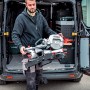 Mann trägt Metabo KGS 254 M Kapp- und Zugsäge aus einem Transporter. Inkl. 2 Sägeblätter.