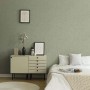 Salbeigrüne Vliestapete mit Betonstruktur im Schlafzimmer. Dekorative Tapete für ein modernes Ambiente.
