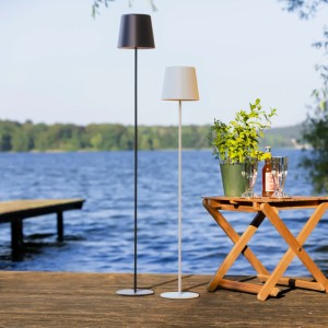 Schwarze und weiße LED-Stehleuchte Kaami, 130 cm, auf einer Terrasse am See.
