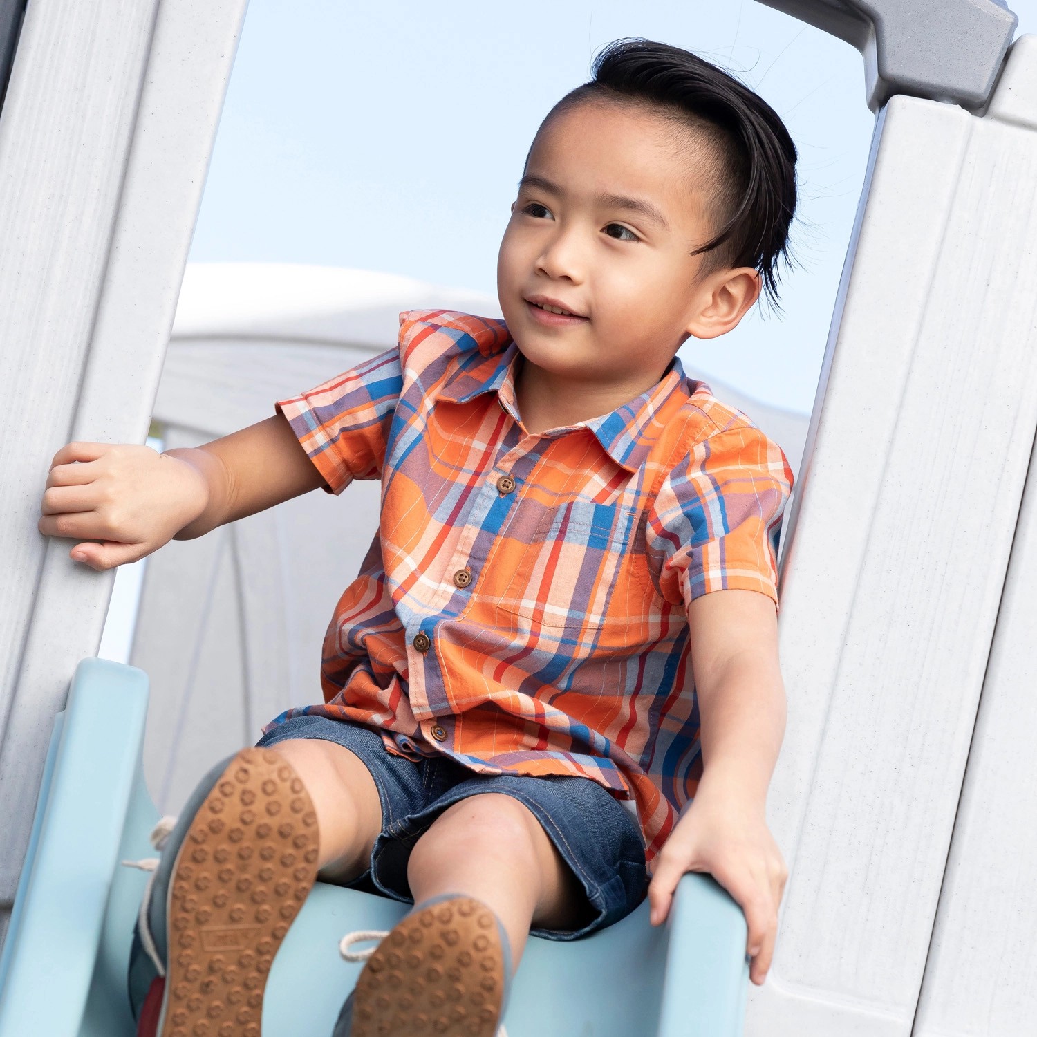 Kind rutscht auf der Rutsche des Step2 Spielhaus Adventures. Zweistöckiges Spielhaus mit Rutsche.