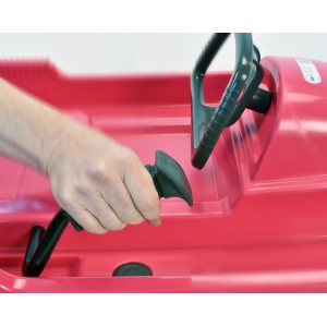 Detailaufnahme: Hand betätigt Bremse am pinken KHW Lenkschlitten Snow Fox.