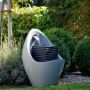 Großer, grauer Design-Gartenbrunnen in Ei-Form mit LED-Beleuchtung im Garten.