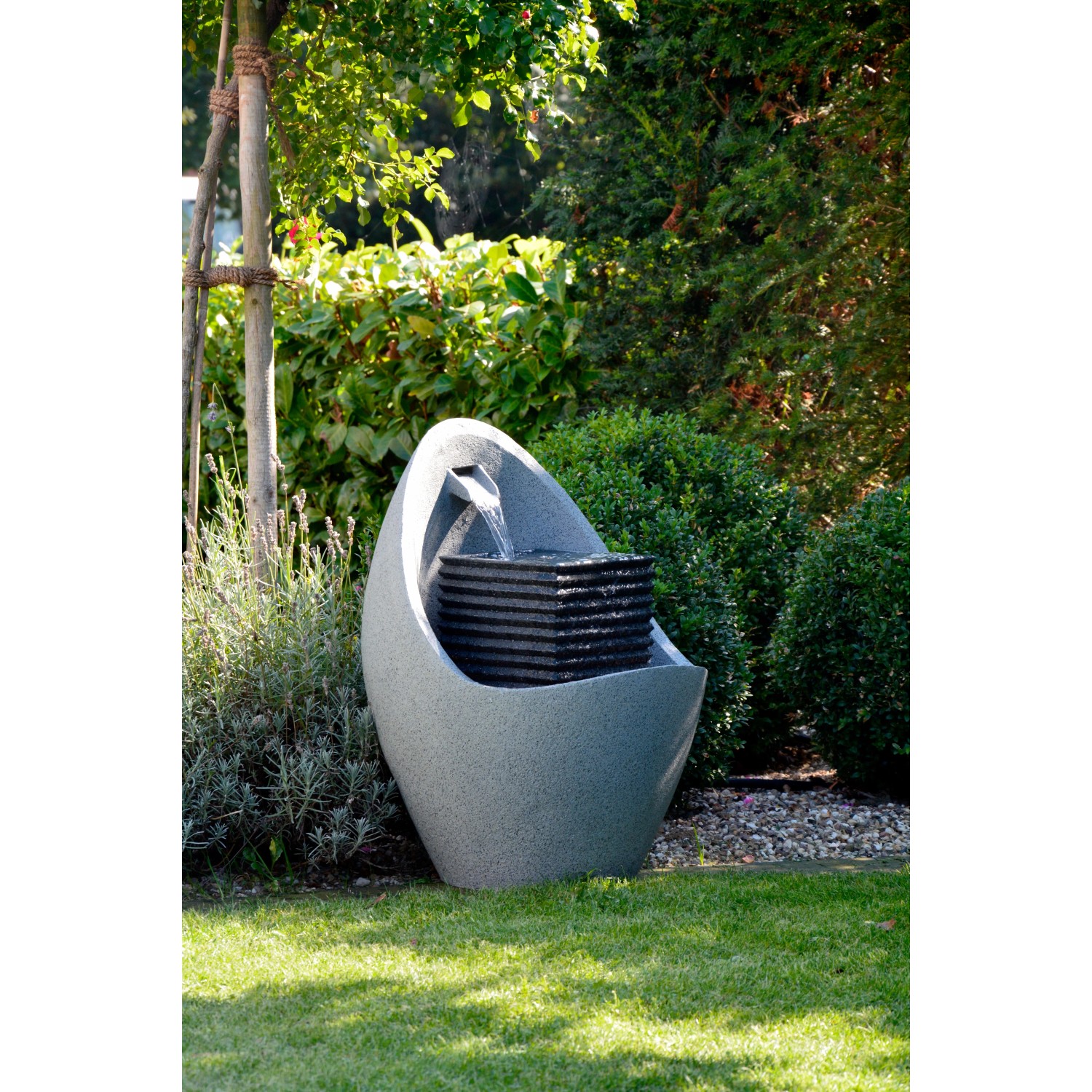 Großer, grauer Design-Gartenbrunnen in Ei-Form mit LED-Beleuchtung im Garten.
