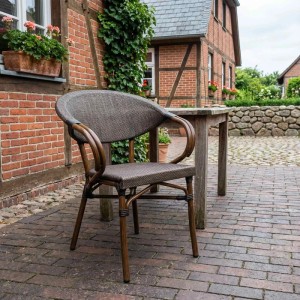 Eleganter Gartenstuhl Madetta in Coffee-Braun mit geflochtener Optik auf gepflasterter Terrasse.