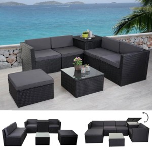 Anthrazitfarbene Poly-Rattan Lounge-Garnitur mit Staufach und dunkelgrauen Kissen vor Meer.