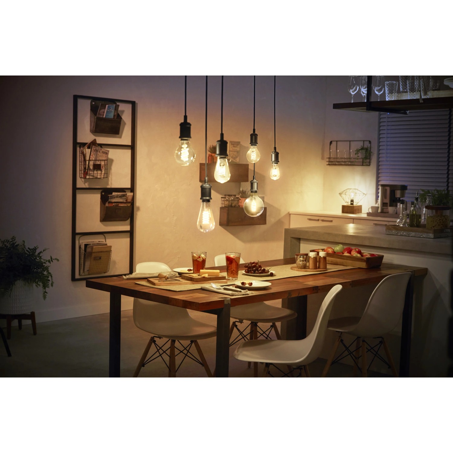 Philips Hue Filament Lampe E27 über Esstisch, warmweißes Licht im Retro-Look.