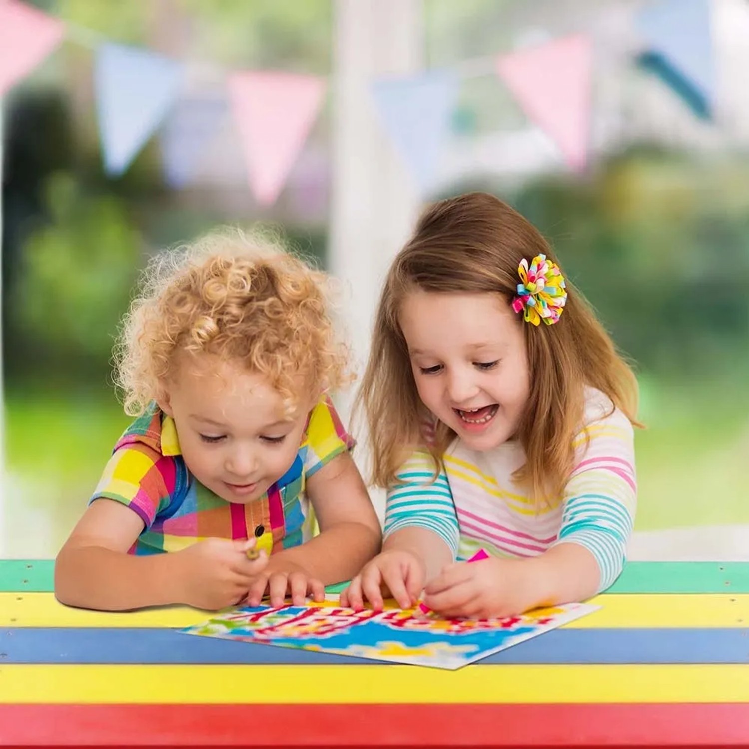Zwei Kinder malen am bunten Axi Nick Picknicktisch Regenbogen mit Sonnenschirm.
