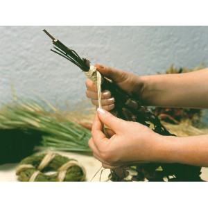 Hände binden Blumenstrauß mit Naturbast. Naturfarbener Bast für Deko- und Gartenarbeiten.