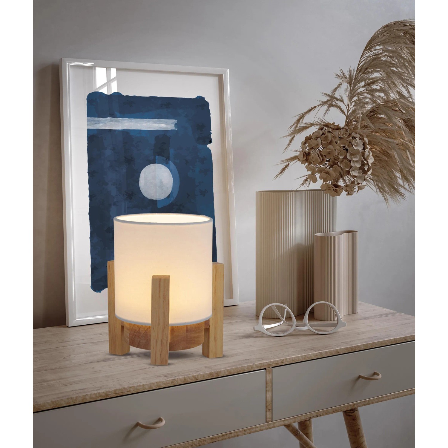 Näve LED-Akkutischleuchte Madita mit Holzfuß und weißem Textilschirm auf Kommode.