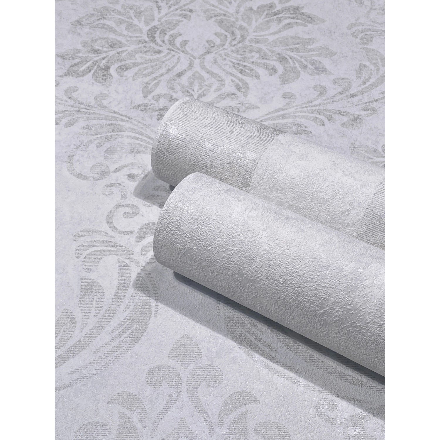 Graue Marburg Vliestapete GZSZ in Betonoptik mit floralem Muster, gerollt.