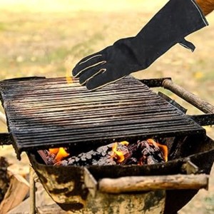 Schwarze Sannover Grillhandschuhe aus Leder über einem Grill mit Feuer. Hitzebeständige Kaminhandschuhe.