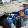 Mann mit blauem LUX Kapselgehörschutz beim Bohren. Gehörschutz für Heimwerker.