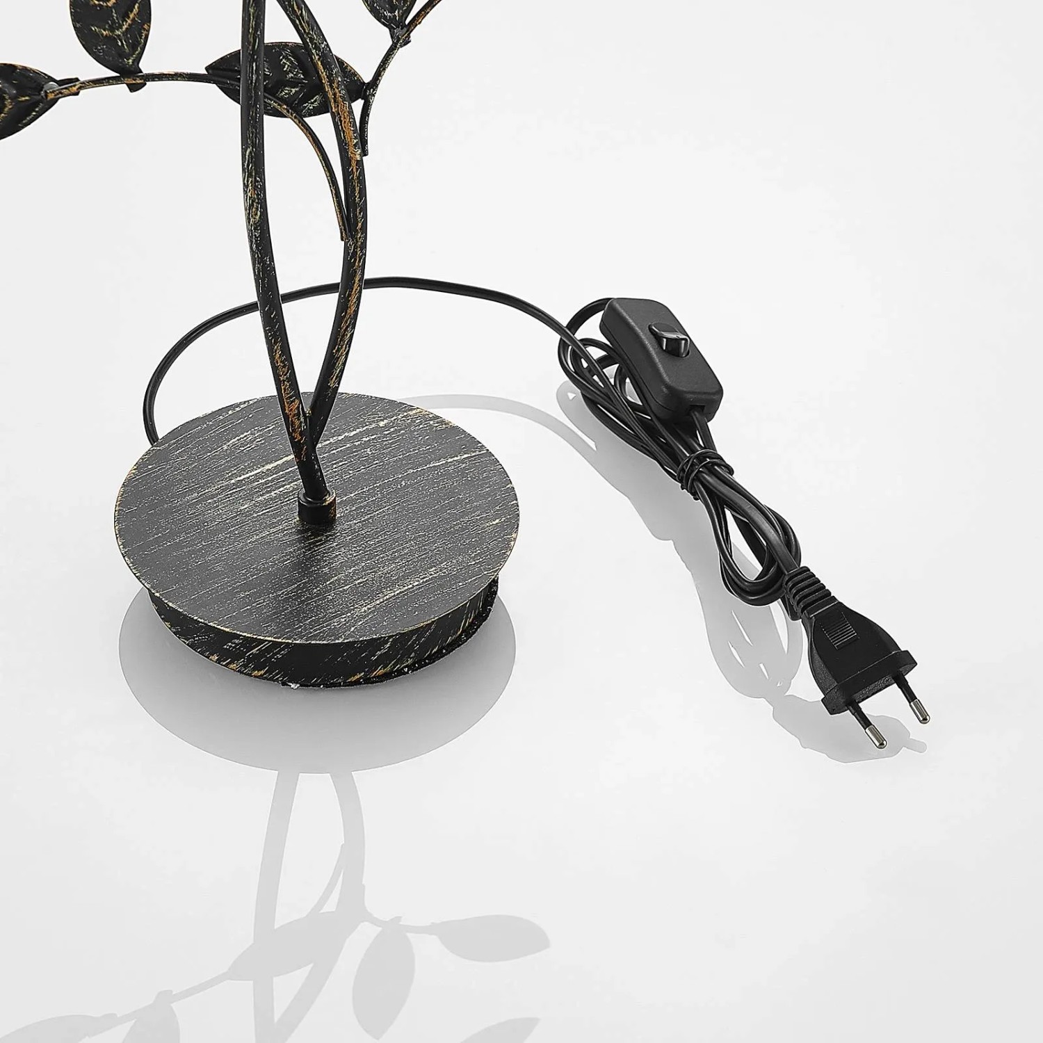Detailaufnahme der schwarzen Lucande Evory Tischlampe im Florentiner-Design mit Schalter und Stecker.