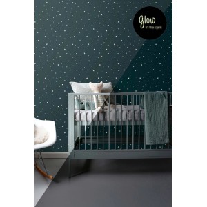 Dunkelblaue Vliestapete mit fluoreszierenden Sternen im Kinderzimmer. Zeigt den Glow-in-the-Dark Effekt.