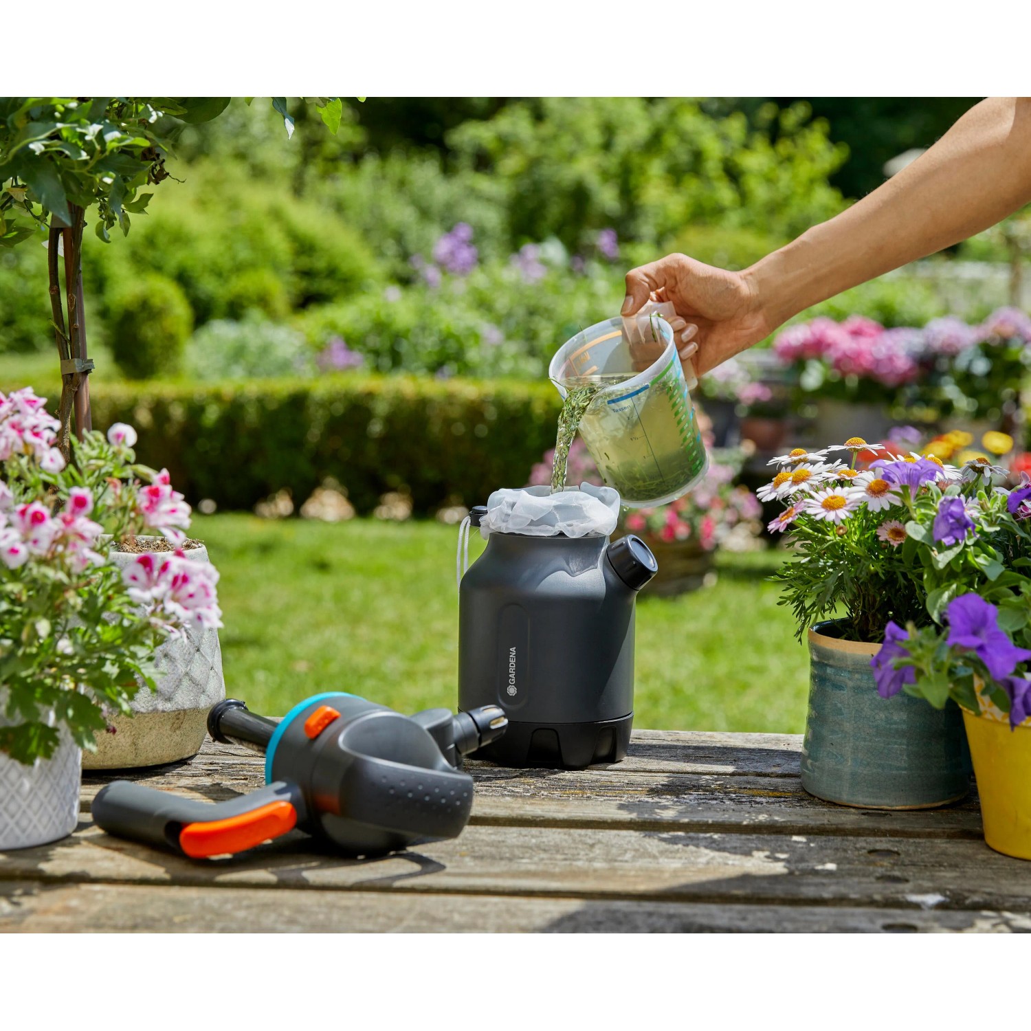 Gardena Drucksprüher 1,25 l beim Befüllen mit Flüssigkeit im Garten.