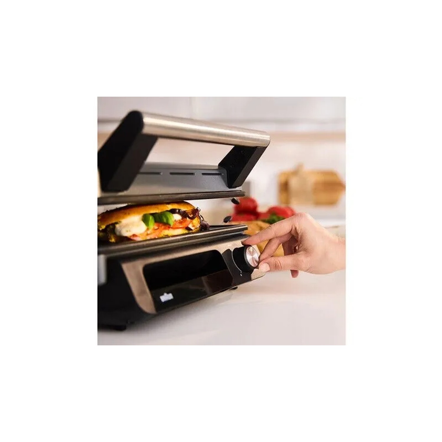 Braun Multigrill Kontaktgrill (grau) mit Sandwich und Hand am Temperaturregler.