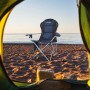 Blauer 24MOVE Campingstuhl, faltbar, gepolstert, mit Tragetasche, max. 150kg, am Strand.