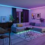 Wohnraum mit Paulmann LED-Strip MaxLED 1000 RGBW, der farbiges Licht an Decke und unter Sofa spendet.