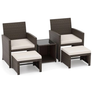 Braunes Rattan Gartenmöbel Balkonset: 2 Sessel, 2 Ottomanen, 1 Couchtisch mit Glasplatte und weißen Kissen.