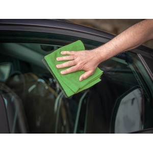 Hand wischt Autoscheibe mit grünem Microfasertuch (3er Set) zur Autopflege.